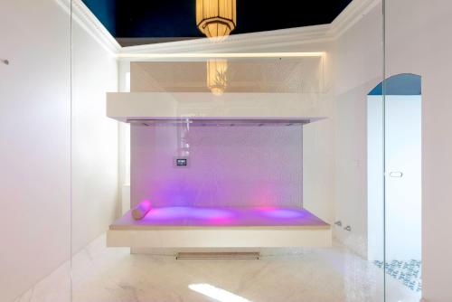 a purple tub in a room with a glass wall at Sant'Angelo, Matera - Small Luxury Hotels in Matera