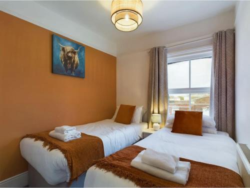 a hotel room with two beds and a window at Central Eastbourne Escape with Rooftop Jacuzzi in Eastbourne