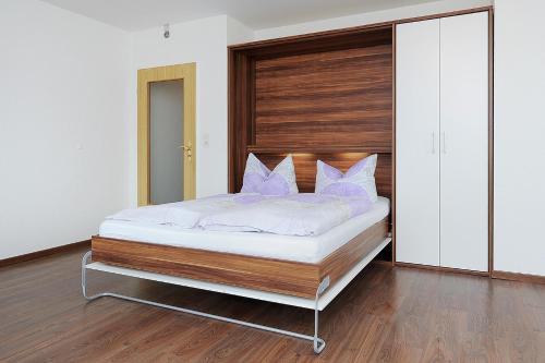 a bedroom with a bed with purple pillows at Haus Hafenromantik in Neuharlingersiel