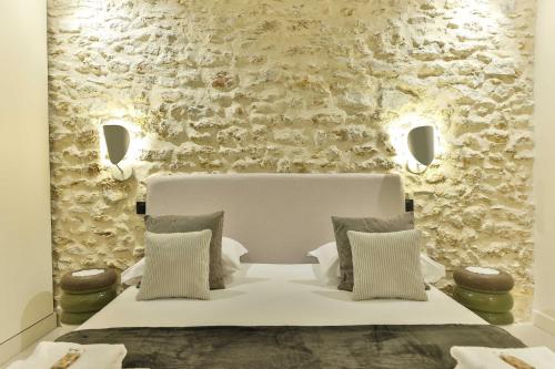 une chambre avec un lit blanc et un mur en pierre dans l'établissement Beautiful 1-bedroom apartment 2pers rue du commerce Eiffeil Tower, à Paris