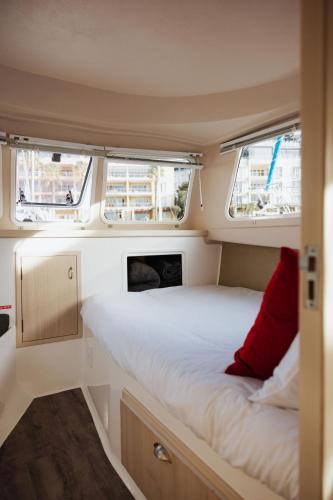 a small bedroom with a bed in the middle of a caravan at Waterfront Houseboat in Cape Town