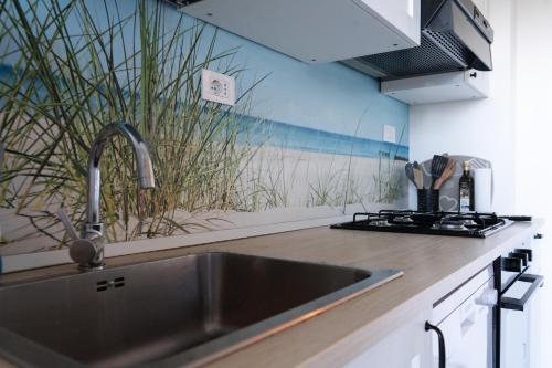 a kitchen sink with a mural of a beach at Giardino delle Fate in Villa Rosa
