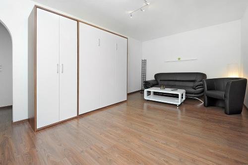 a living room with two chairs and a large white cabinet at Haus Hafenromantik in Neuharlingersiel