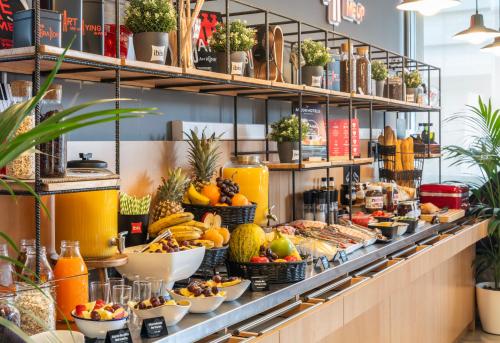 a buffet line with fruits and vegetables on display at Ibis Barcelona Meridiana in Barcelona