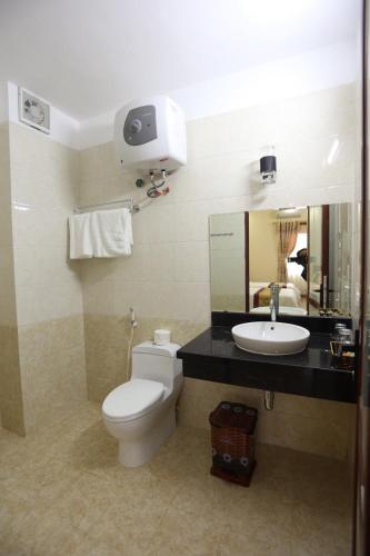 a bathroom with a toilet and a sink at Royal Hotel Ha Giang in Ha Giang