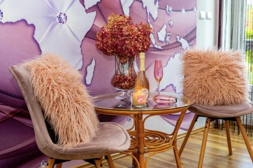 a table with a vase of flowers and two chairs at Vila Marcelka in Broumov