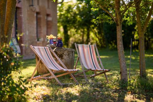 two chairs sitting next to a table in the grass at L'Apouticayre in Montaut