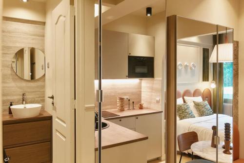 une petite salle de bain avec un lavabo et un lit dans l'établissement Saint Charles Room - Duke Housing, à Paris