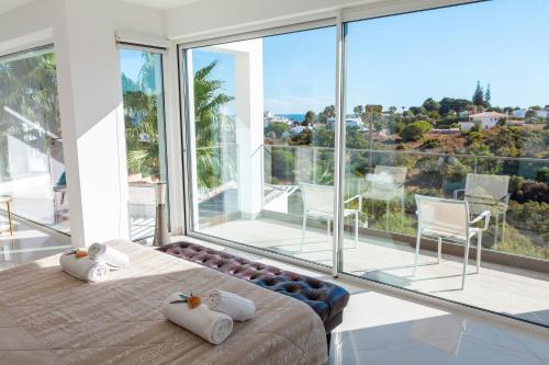 Schlafzimmer mit einem Bett und großen Glasfenstern in der Unterkunft Villa Catalina by Algarve Vacation in Armação de Pêra