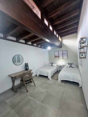 a room with two beds and a wooden table at Granillo Beach Calm in Costa Calma
