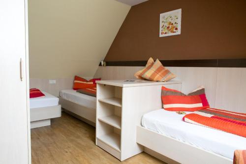 a small room with two beds and a desk at Landhuus Laurenz in Am Berge