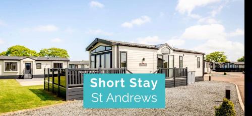 a home in a suburb with a sign that reads short stay st austhews at Lodge No 20 - Stewart's Resort Cameron in St. Andrews