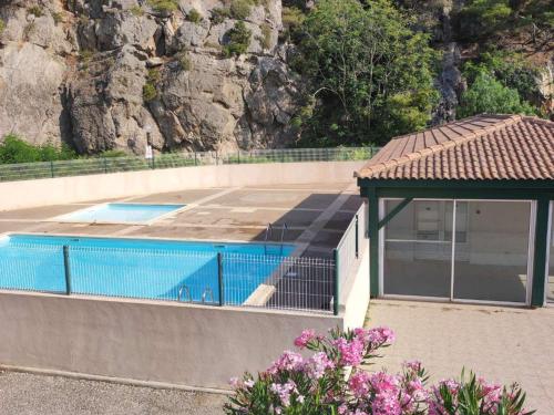 - une piscine avec un kiosque à côté d'une montagne dans l'établissement Appartement Climatisé 2P Avec Piscine et Parking à 500m de la Plage - Narbonne-Plage - FR-1-409-211, à Narbonne