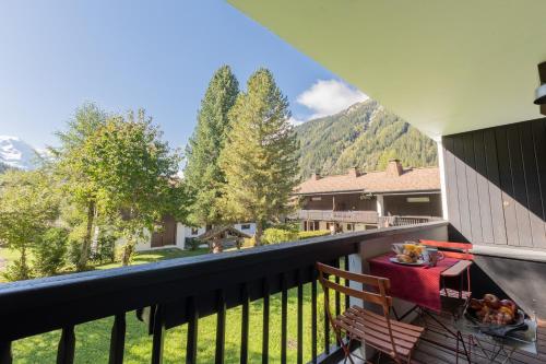 d'un balcon avec une table et une vue sur les montagnes. dans l'établissement Appartement T4 familial à Chamonix, avec Parking et près des Grand Montets, à Chamonix-Mont-Blanc
