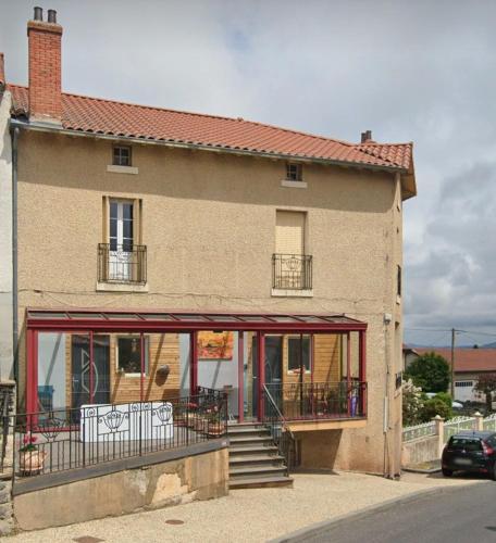 a building with a balcony and stairs in front of it at Gite Bains jolivet in Bains