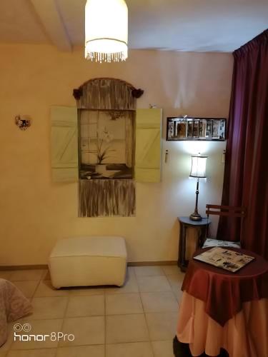 a living room with a chair and a table and a chandelier at La Demeure de la Vendémière in Pont-Melvez