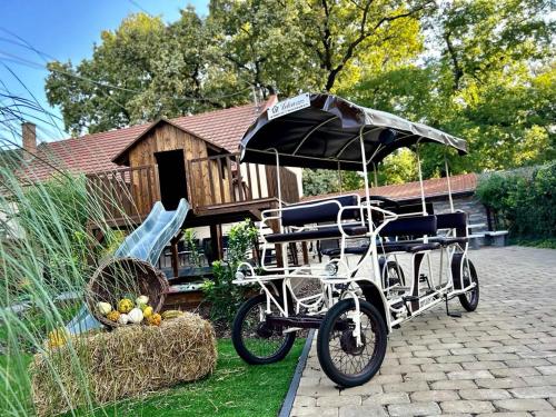 a bike with an umbrella parked in front of a house at Éden Vendégház Gyula in Gyula