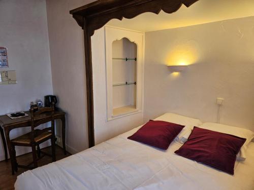 a bedroom with a bed with two red pillows at Logis Hôtel restaurant Chez Jeannette in Fixin