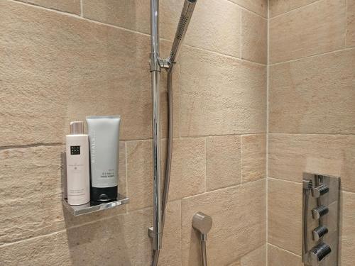 a shower in a bathroom with a soap dispenser at Residence Moai - Exklusiver Rückzugsort für Geschäftsreisen - kostenloser Parkplatz, WLAN, Waschtrockner, Smart TV, Qbo ESSENTIAL, ergonomischer Schreibtisch in Erlangen