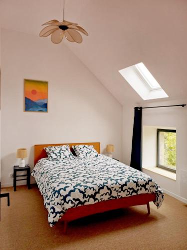 une chambre avec un lit et un ventilateur de plafond dans l'établissement La Garencière - Les 3 pommes, à Champfleur