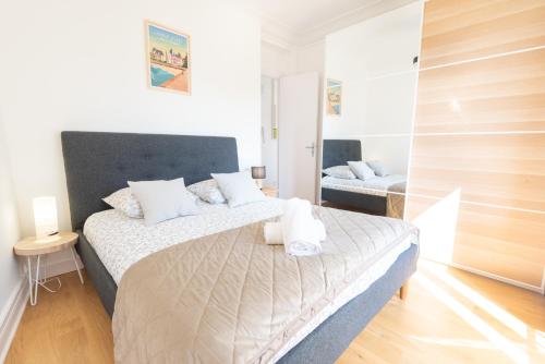une chambre avec un grand lit et un miroir dans l'établissement Appartement Premium 3ème Ultra Centre Lorient par Groom, à Lorient