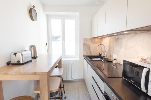 une cuisine avec un comptoir en bois et un évier dans l'établissement Appartement Premium 3ème Ultra Centre Lorient par Groom, à Lorient
