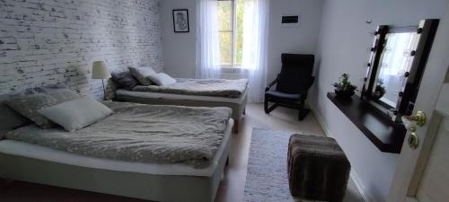 a room with two beds and a chair in it at Lottefors Logi in Bollnäs
