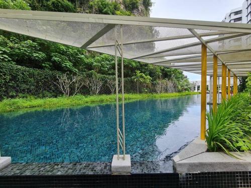 a pool of water with a canopy over it at The Cove Hillside Residence Ipoh-Nature On Earth in Ipoh