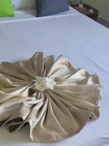 a bed with a flower made out of a blanket at Sunset View Self Catering in Anse Boileau