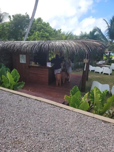 a restaurant with a bar in a grass roof at Sunset View Self Catering in Anse Boileau