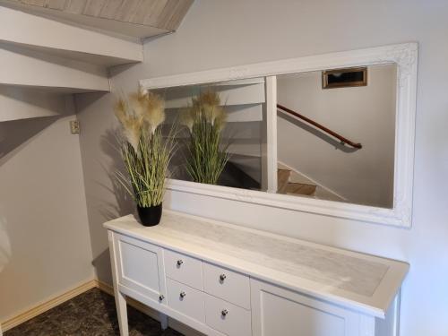 a bathroom with a mirror and a white dresser at Lottefors Logi in Bollnäs