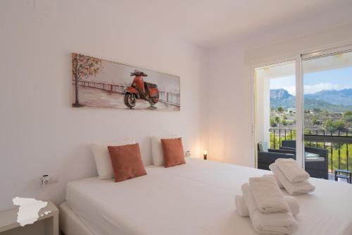 a white bedroom with a large white bed and a window at CostaBlancaDreams Casa Tinick in Calpe in Empedrola