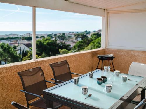 une table et des chaises sur un balcon avec vue dans l'établissement Pavillon 3 pièces, 6 pers, vue mer, clim, animaux, parking - FR-1-409-101, à Fleury