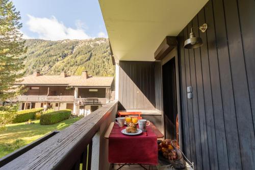 une table avec une assiette de fruits sur un balcon dans l'établissement Appartement T4 familial à Chamonix, avec Parking et près des Grand Montets, à Chamonix-Mont-Blanc