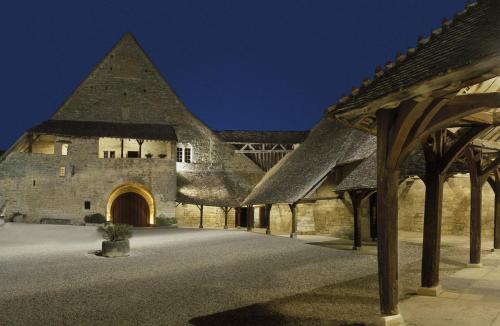 a large stone building with a pointed roof at Logis Hôtel restaurant Chez Jeannette in Fixin