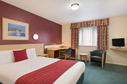 HarthillにあるDays Inn Hotel Sheffield Southのベッドと机があるホテルの部屋