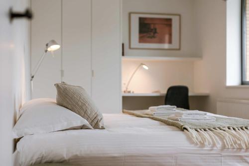 a white bedroom with a bed with a blanket on it at Huswell - Luxury Villa for 8 Guests Near the Beach in Knokke in Knokke-Heist