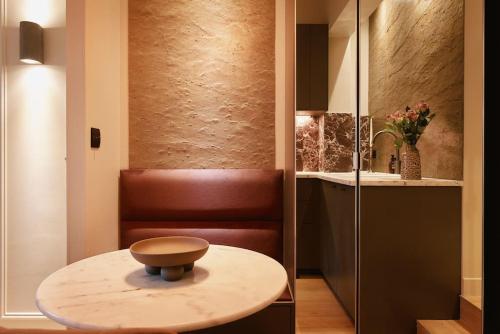 un tabouret assis sur une table dans une salle de bains dans l'établissement Rosso Levanto Room - Duke Housing, à Paris