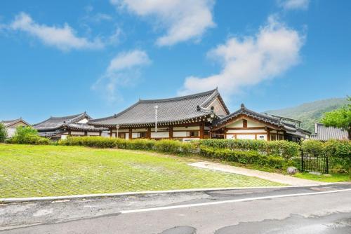 a house on a grassy hill with a building at Boseong Greenery Hanok Pension in Boseong