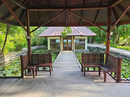 two benches sitting on a wooden walkway with a building at Filitheyo Island Resort in Filitheyo