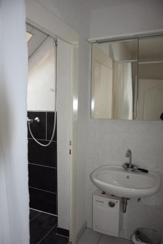 a white bathroom with a sink and a shower at Bergmühle Simmertal in Simmertal