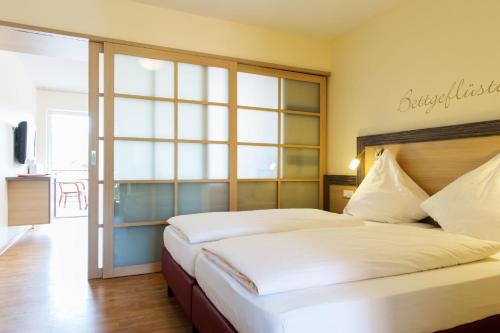 a bedroom with a large bed and a large window at Landhuus Laurenz in Am Berge