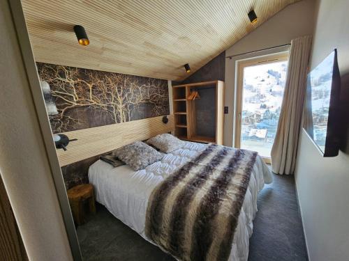 a bedroom with a bed in a room with a window at Le 4 in Les Deux Alpes