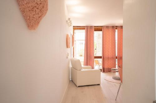 sala de estar con silla blanca y ventana en Casa Alejandro WIFI & POOL & 24H SECURITY, en Arona
