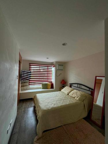 sypialnia z dużym łóżkiem i oknem w obiekcie bendetto residences w mieście Manila