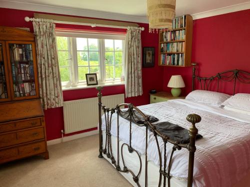 a bedroom with a bed with red walls and a window at Inkerman in Lavant