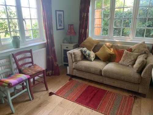 a living room with a couch and a chair and windows at Inkerman in Lavant