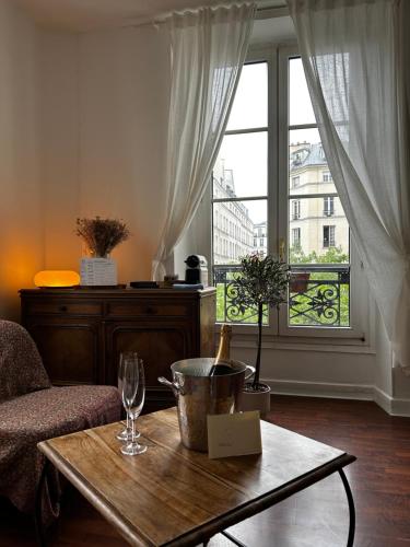 un salon avec une table et une fenêtre dans l'établissement Appartement en plein coeur du Marais, à Paris