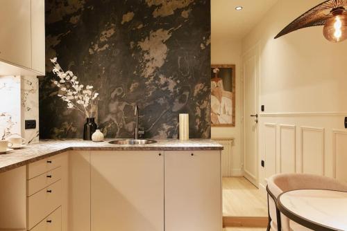 - une cuisine avec un évier et un mur noir et blanc dans l'établissement Saint Lambert Suite - Duke Housing, à Paris