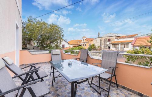 セニにあるLovely Apartment In Senj With Wifiのバルコニーにテーブルと椅子が置かれたパティオ